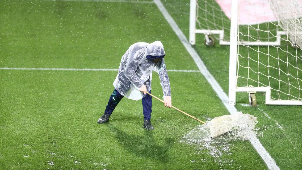 Funcionários trabalham para drenar o gramado do estádio Couto Pereira.